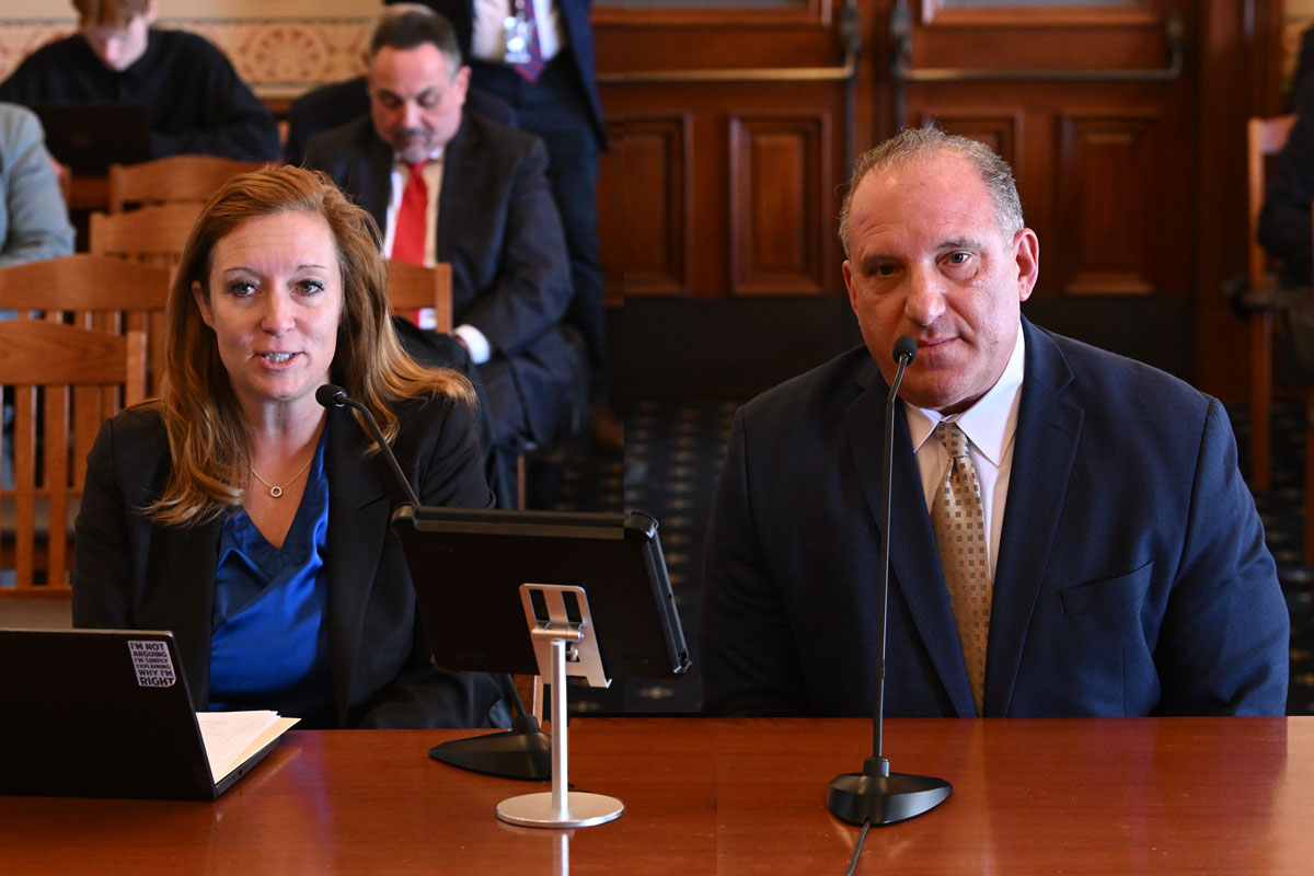 Kane County State’s Attorney Jamie Mosser, left, and Detective Rich Wistoki, right, are seated side by side at a wood table. They initiated SB 2741, and testified on Holmes’ bill in committee.